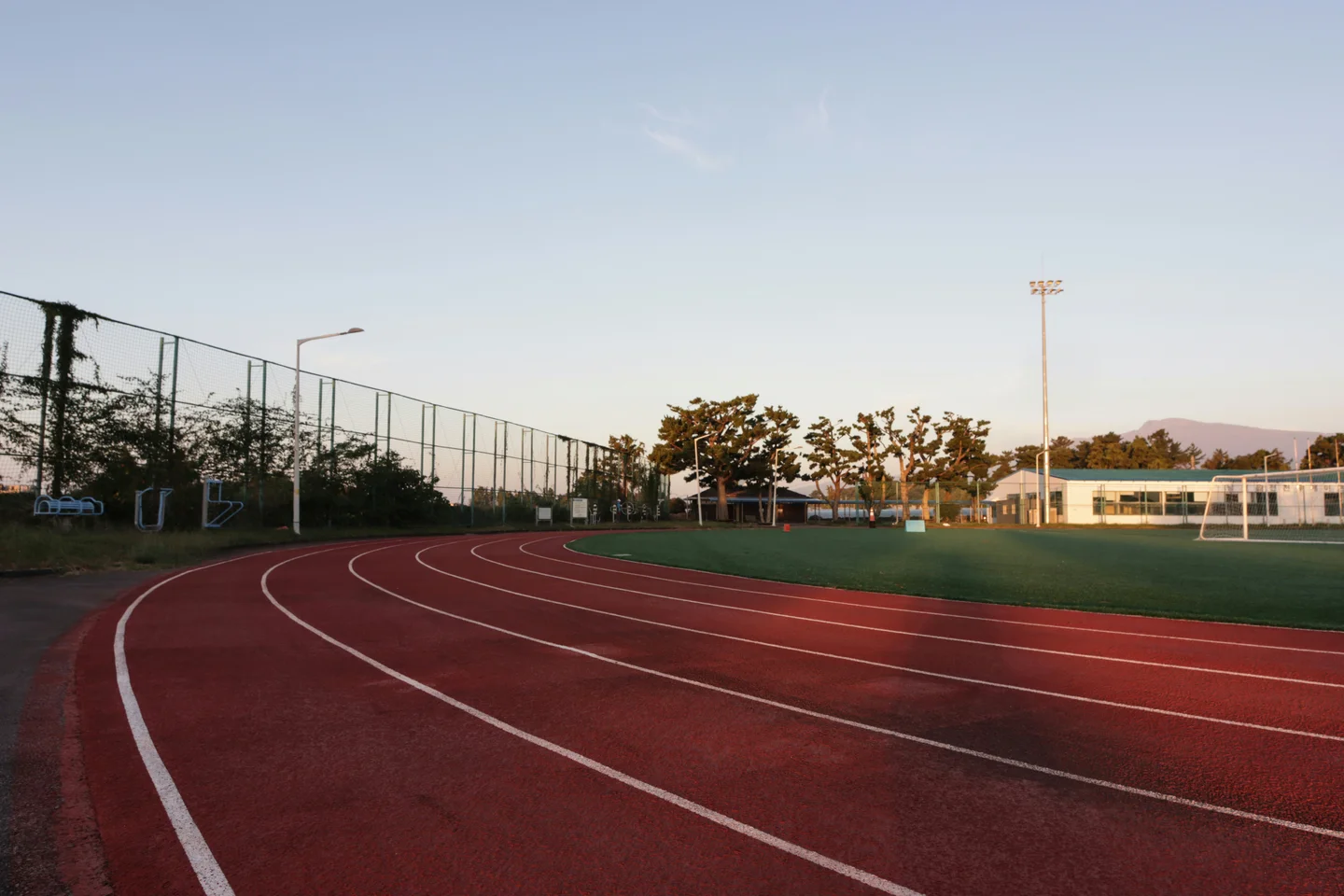 Hard courts with floodlights at dusk